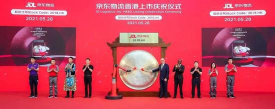 9名客户和员工代表与象征京东物流科技的六轴协作机械臂共同敲响上市锣声。图片来源:京东物流供图